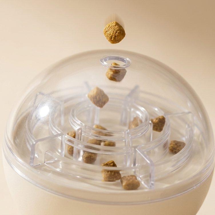 A piece of kibble dropping into the fill hole at the top of the Naïa Malin toy's clear dome